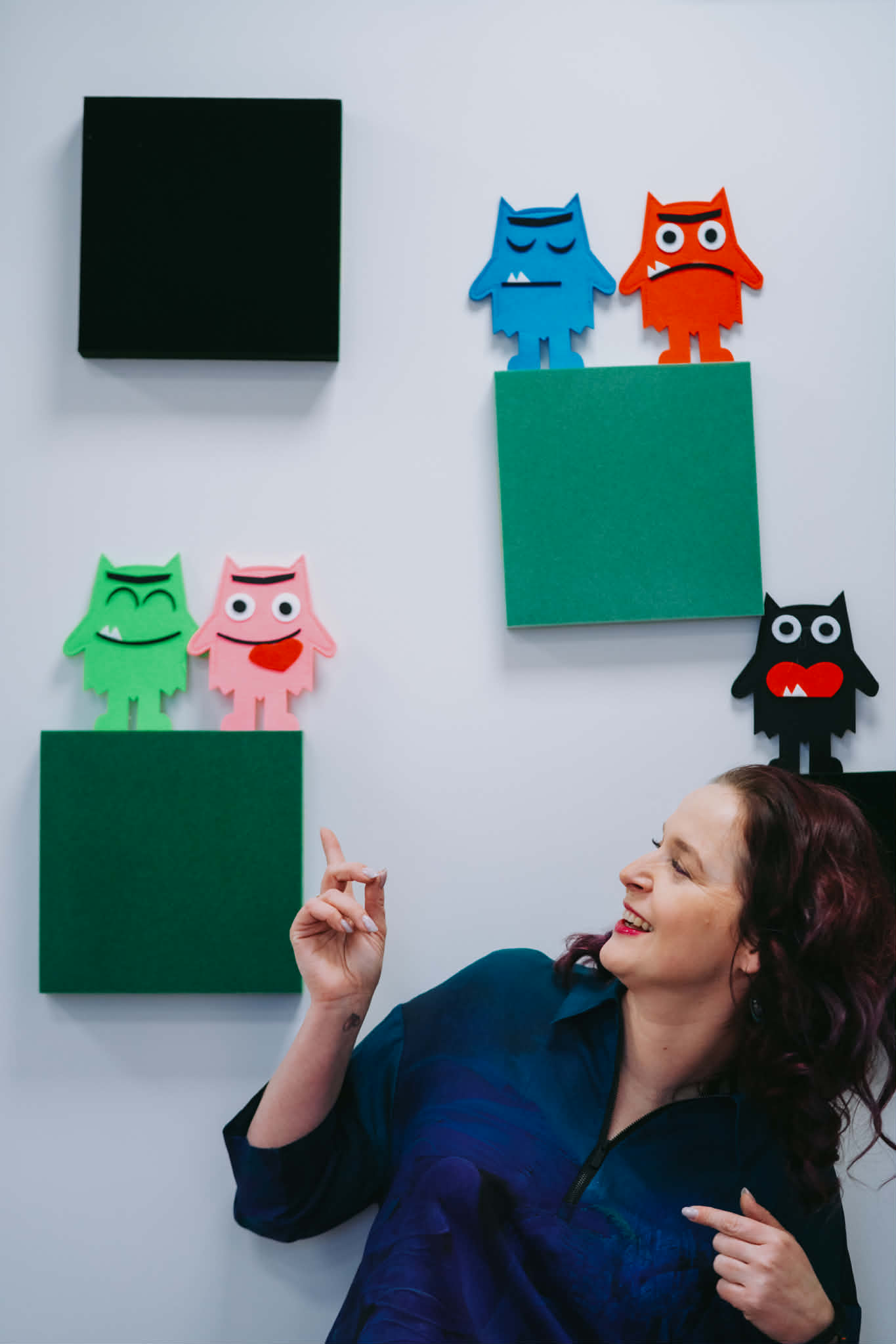 Terapeutka głaszcze konia, który zajada trawkę.